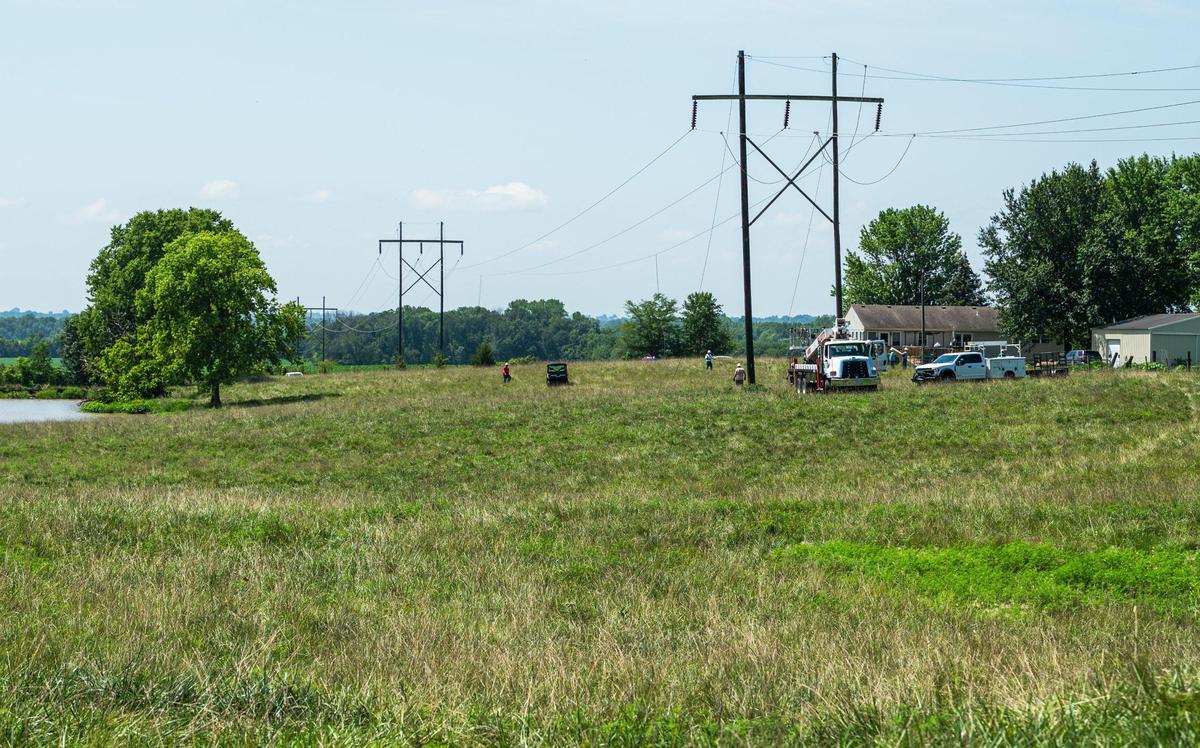 Crews with the NW Electric Power Collective asses damaged power lines that were downed during a fatal plane crash on Thursday, July 20, 2023, in Kearney. The plane crashed in a field near NE 150th Street and Cordell Road shortly after taking off from Midwest Regional Air Center.