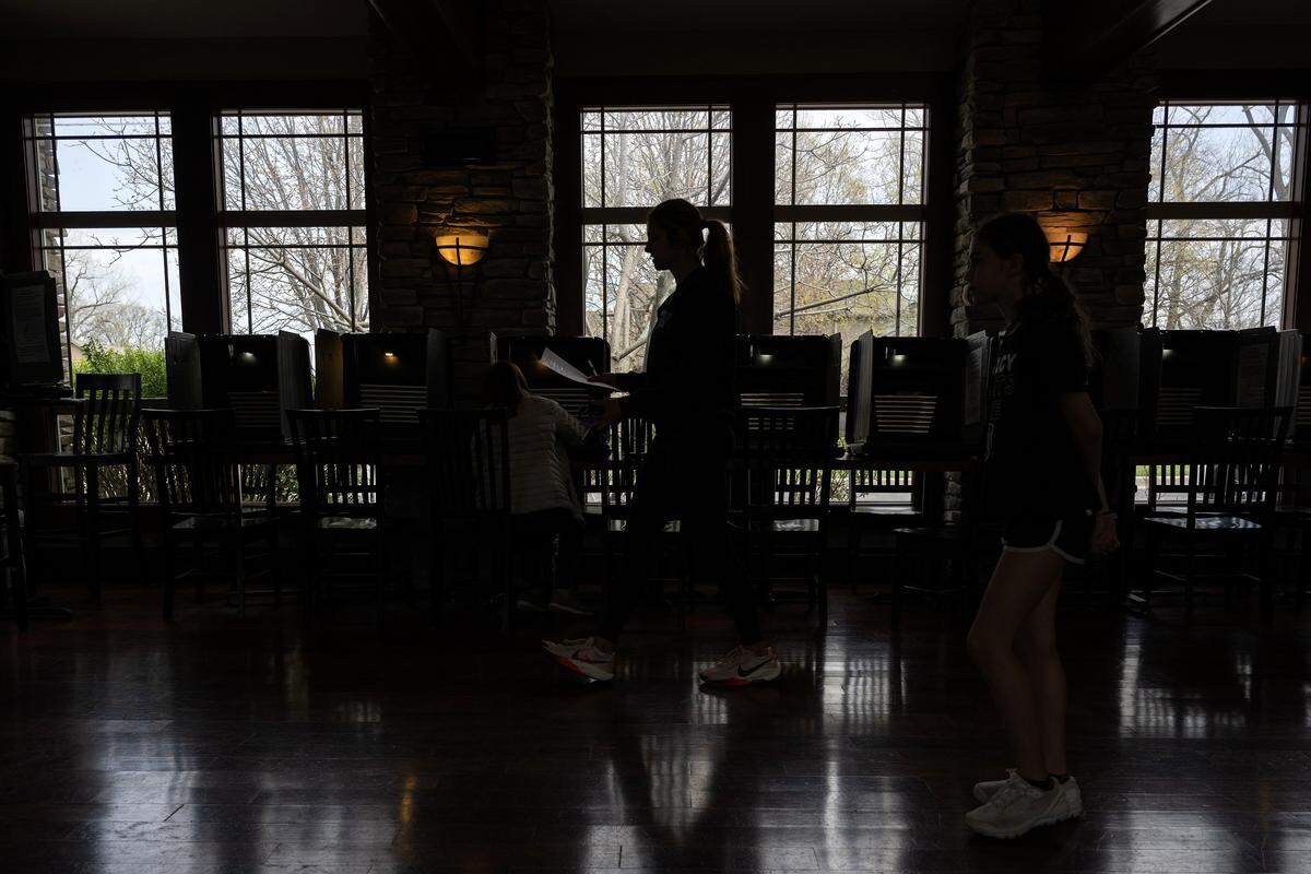 The silhouette of a person is seen near voting booths at Thousand Oaks Oasis Pool and Clubhouse during Election Day on Tuesday, April 7, 2026, in Parkville.