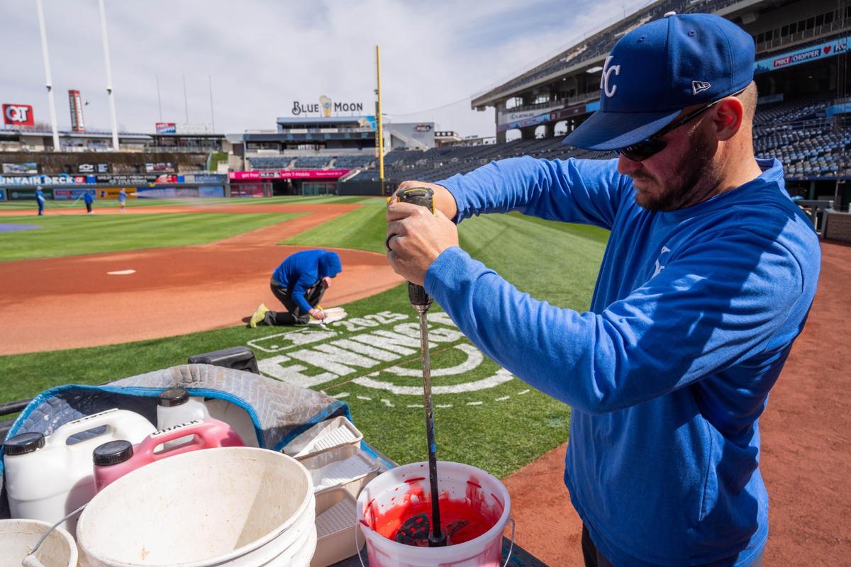 Clinton Elder, a grounds crewman for the Royals, mixes red paint for the MLB Opening Day logo on the field at Kauffman Stadium on Tuesday, March 25, 2025.