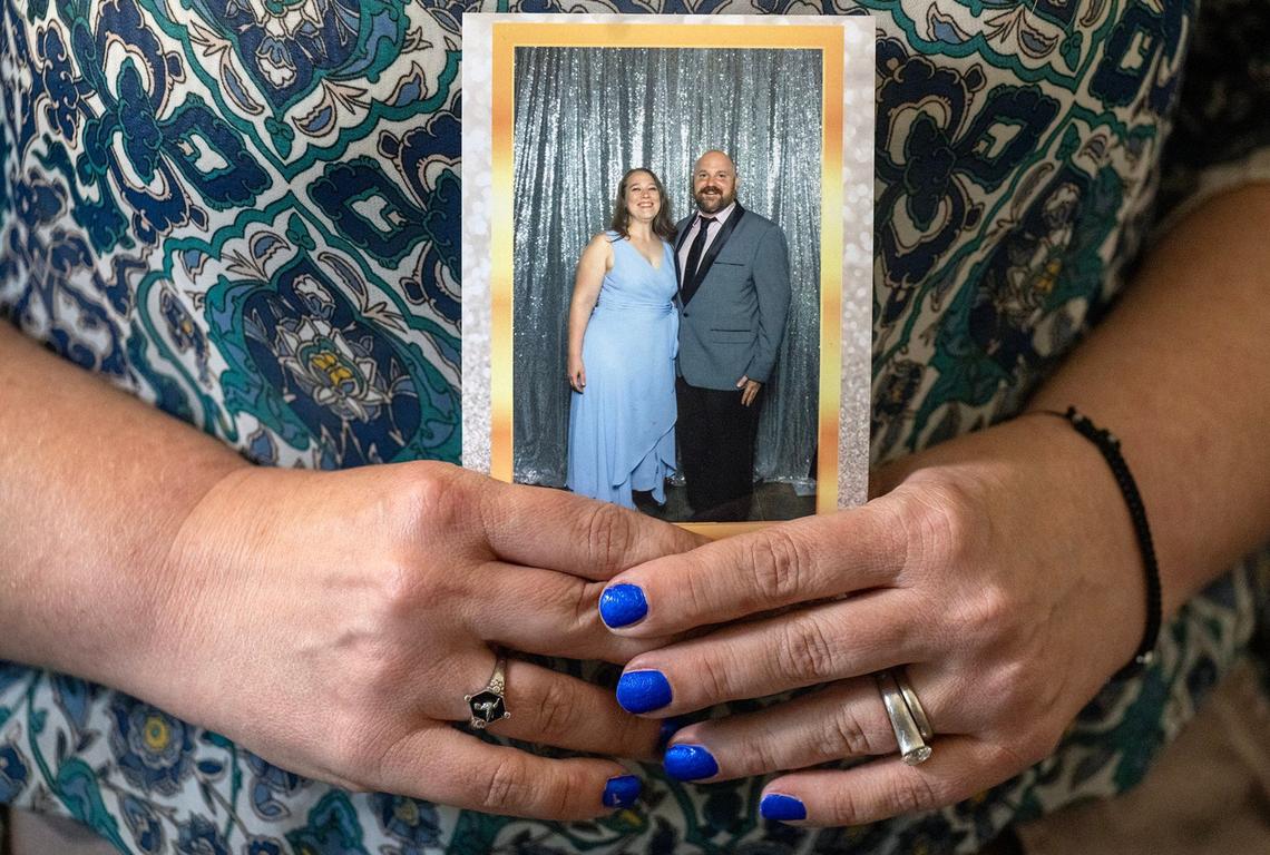 “I realized that nothing was the way I thought it was,” said Laura Beth Mahoney, whose ex-husband, pastor Justin Meier, lied about his life and counseled clients into sexual affairs. Mahoney holds a 2018 photo of the couple at a wedding of friends.