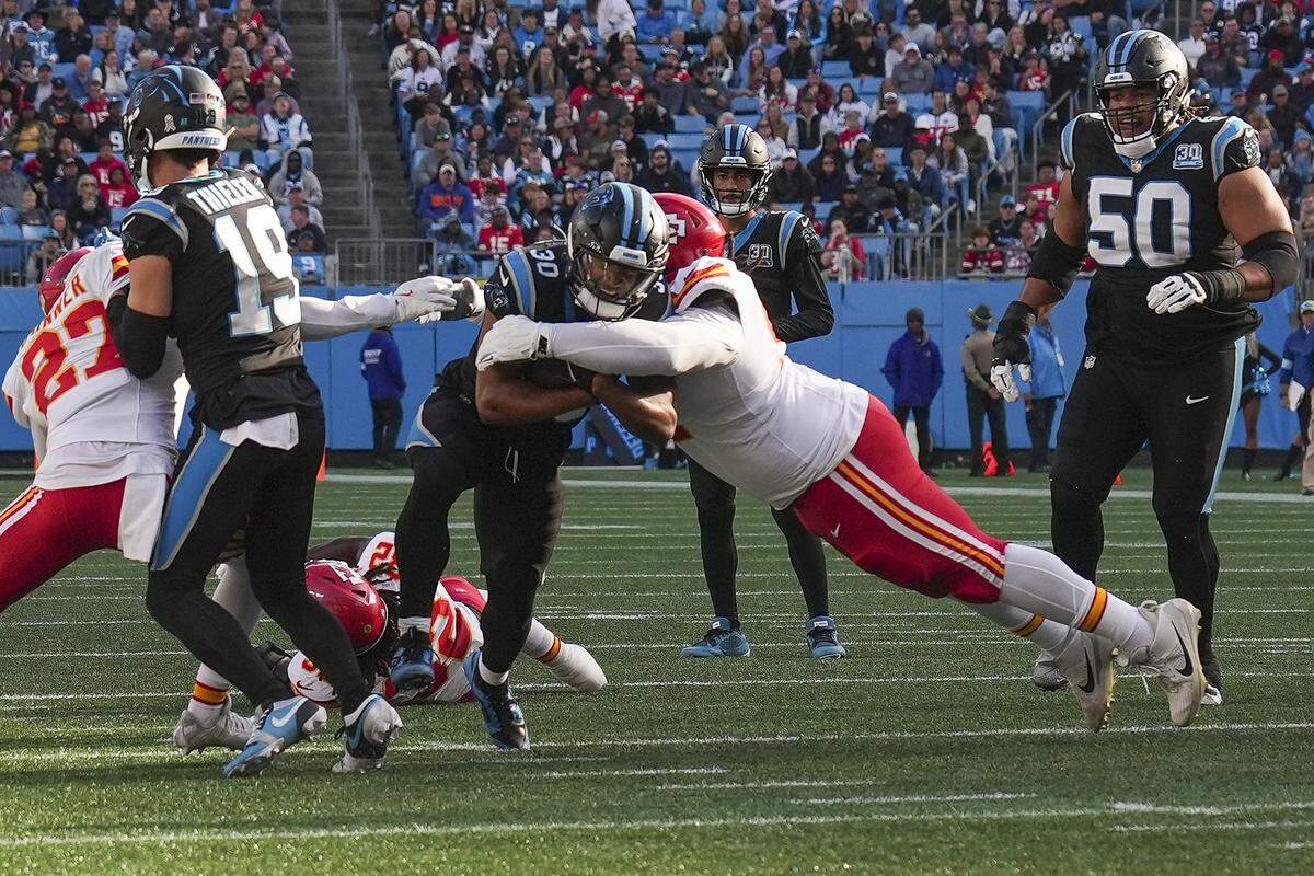 Carolina Panthers running back Chuba Hubbard (30) is tackled by Kansas City Chiefs defensive end Felix Anudike-Uzomah (97) during the second half at Bank of America Stadium.