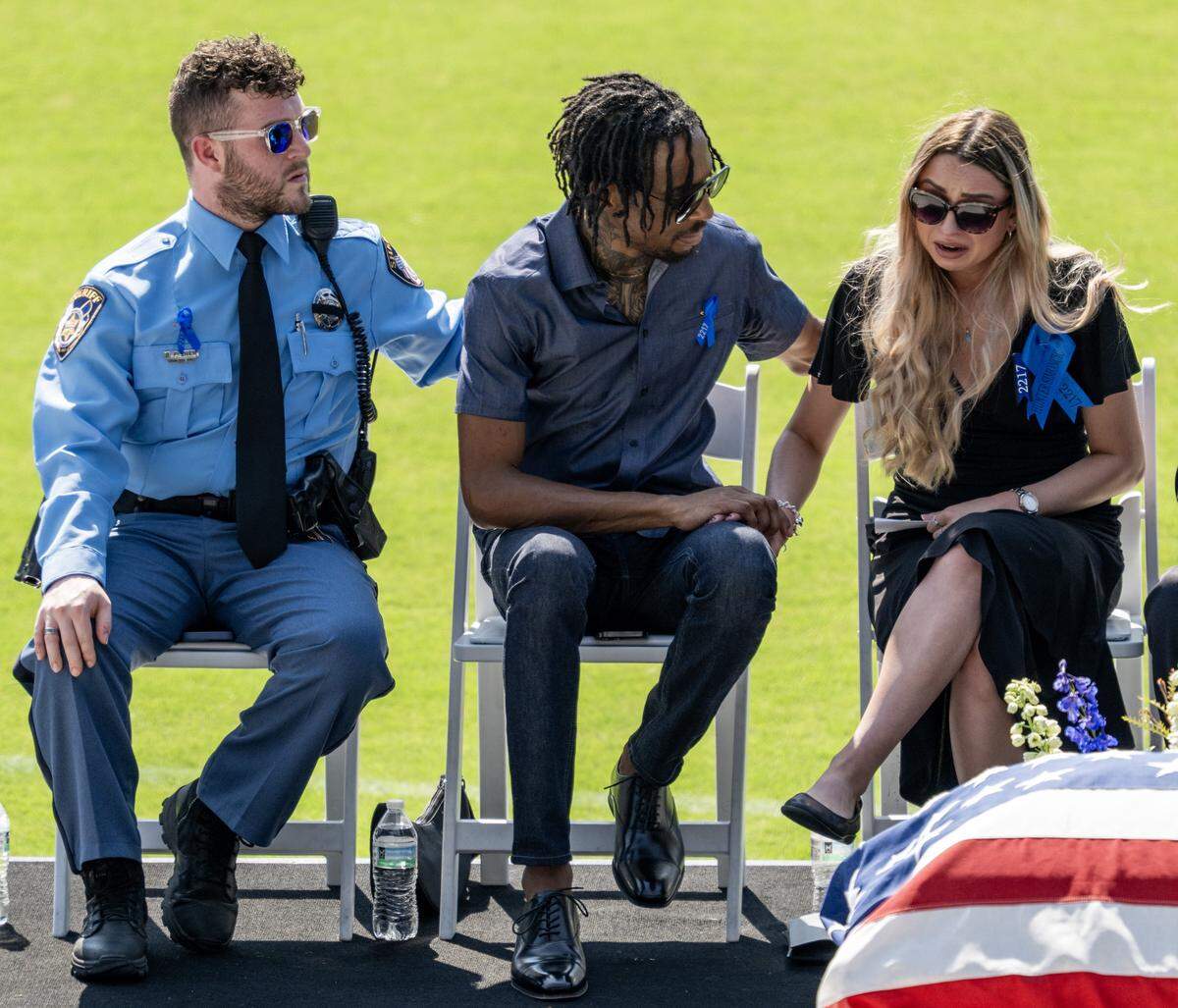 Steven Jennings, center, comforts Sarah Latham after she spoke during the readings of memories at Officer Hunter Simoncic's memorial service at Children's Mercy Park on Wednesday, Sept. 3, 2025, in Kansas City, Kansas. Simoncic was killed Aug. 26 after being struck by a fleeing driver while deploying stop sticks.
