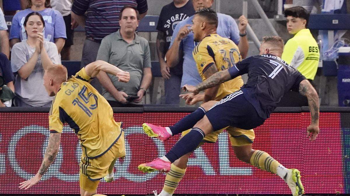 Sporting Kansas City forward Johnny Russell, right, goes airborne to score a first-half goal against Real Salt Lake on Wednesday evening at Children’s Mercy Park in Kansas City, Kan.