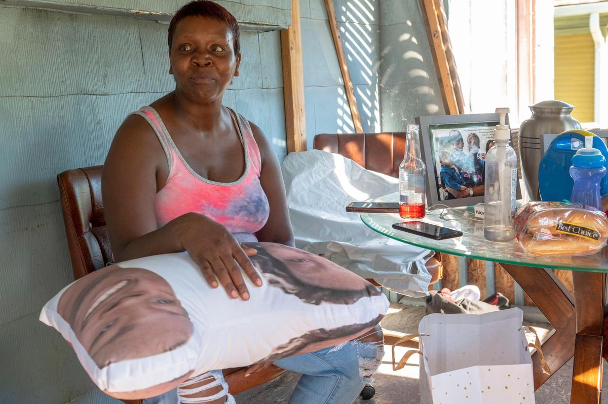 Cynnita Oliver receives the gift of a pillow with her son’s face printed on it during a family gathering at her home. She said she was disappointed that the investigation of his killing never held anyone responsible.