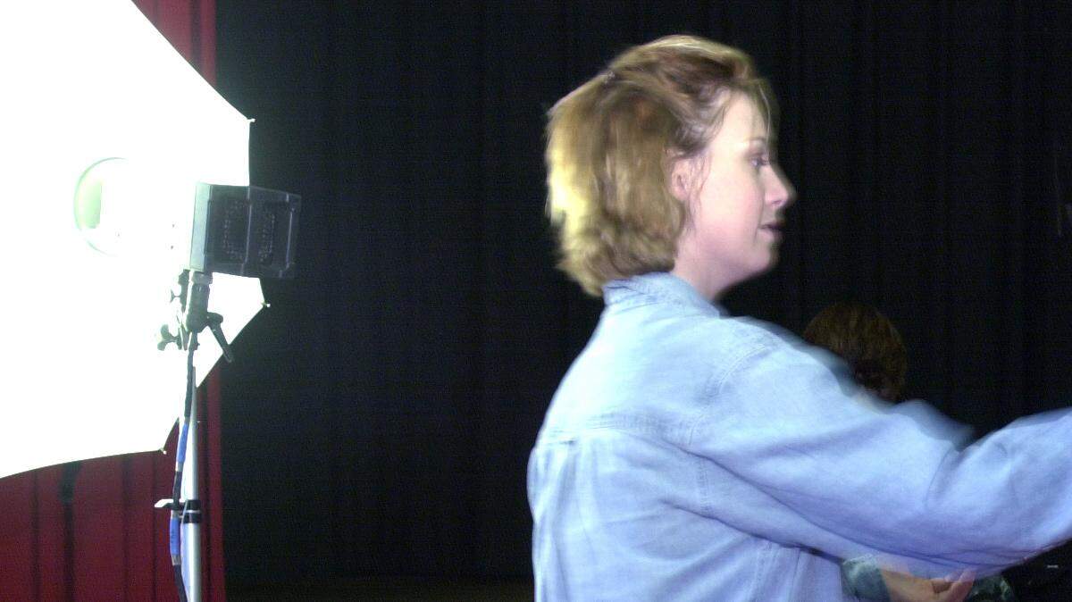 The evolution toward more digital and self-publishing is prompting Lifetouch Inc. to end its Kansas City yearbook publishing operations by Dec. 1.  In this 2001 file photo, Stacy Goins, a photographer for LifeTouch directed Wyandotte High School senior 17-year-old Shyeasta Cullars, then a senior at Wyandotte High School, during a photo shoot at the school.