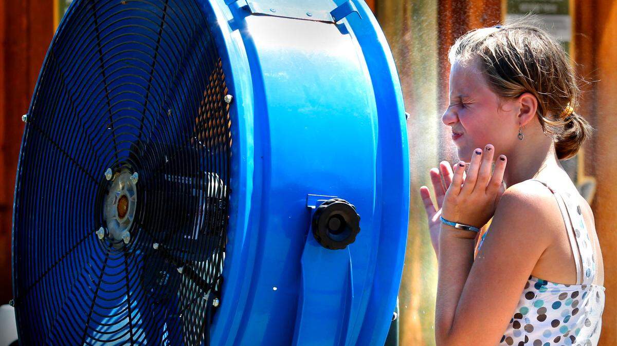 A visitor to the Kansas City Zoo cools off with the help of a misting fan in this file photo.