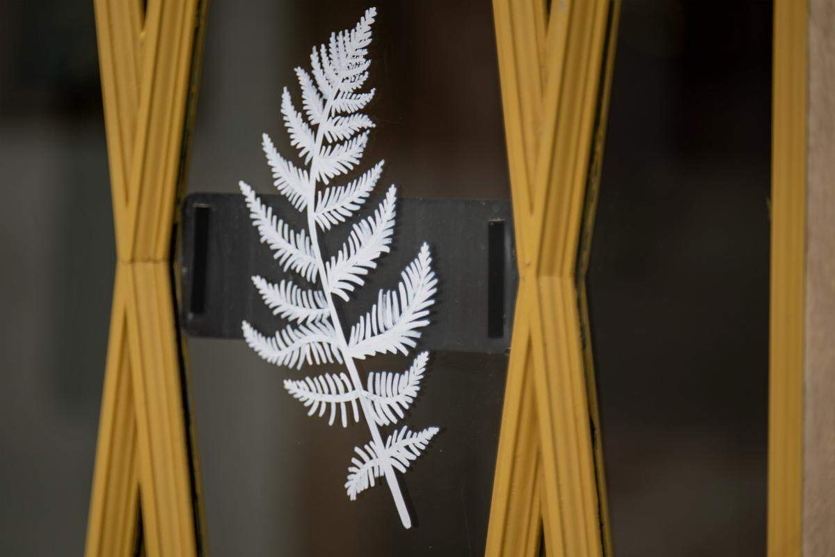 A fern frond graphic adorns the front door at at the Fern Bar, a craft cocktail bar at 2041 Broadway Blvd., in Kansas City.