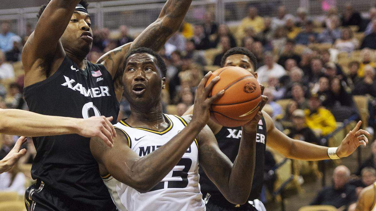 Missouri’s Jeremiah Tilmon, center, tries to shoot between Xavier’s Tyrique Jones, left, and Kyle Castlin.