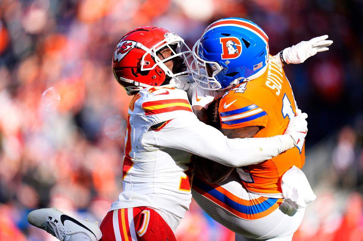 Broncos wide receiver Courtland Sutton, right, makes the catch but is wrapped up by Kansas City Chiefs safety Nazeeh Johnson during the teams’ NFL Week 18 game at Empower Field at Mile High in Denver on Sunday, Jan. 5, 2025.