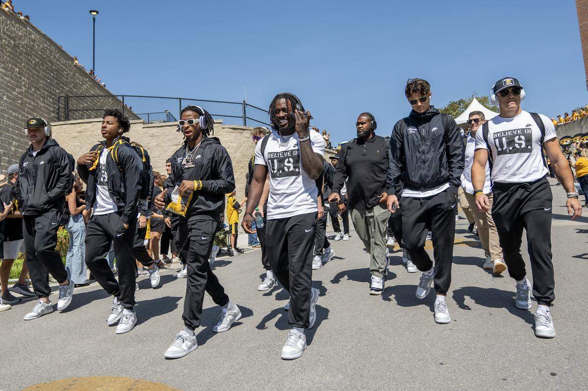 Missouri football players walk down a hill during a pep rally outside Faurot Field at Memorial Stadium before the Tigers' game against the Kansas Jayhawks on Saturday, Sept. 6, 2025, in Columbia.