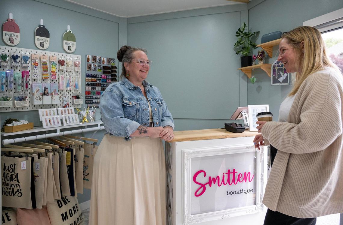 Inside Smitten Booktique, Kara Bowersock, left, spoke with customer Krystal Rosenthal of Overland Park, who had popped into the mobile bookstore on Tuesday. Smitten Booktique operates from a revovated 20-foot cargo trailer.