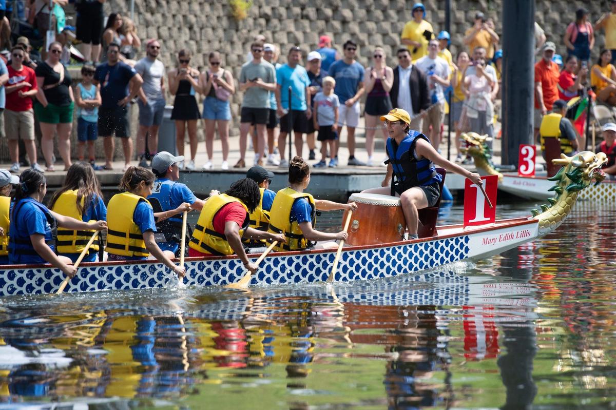 Spectators line the pier to cheer for teams competing in the dragon boat races at the 18th annual Kansas City Dragon Boat Festival on Saturday, along Brush Creek.