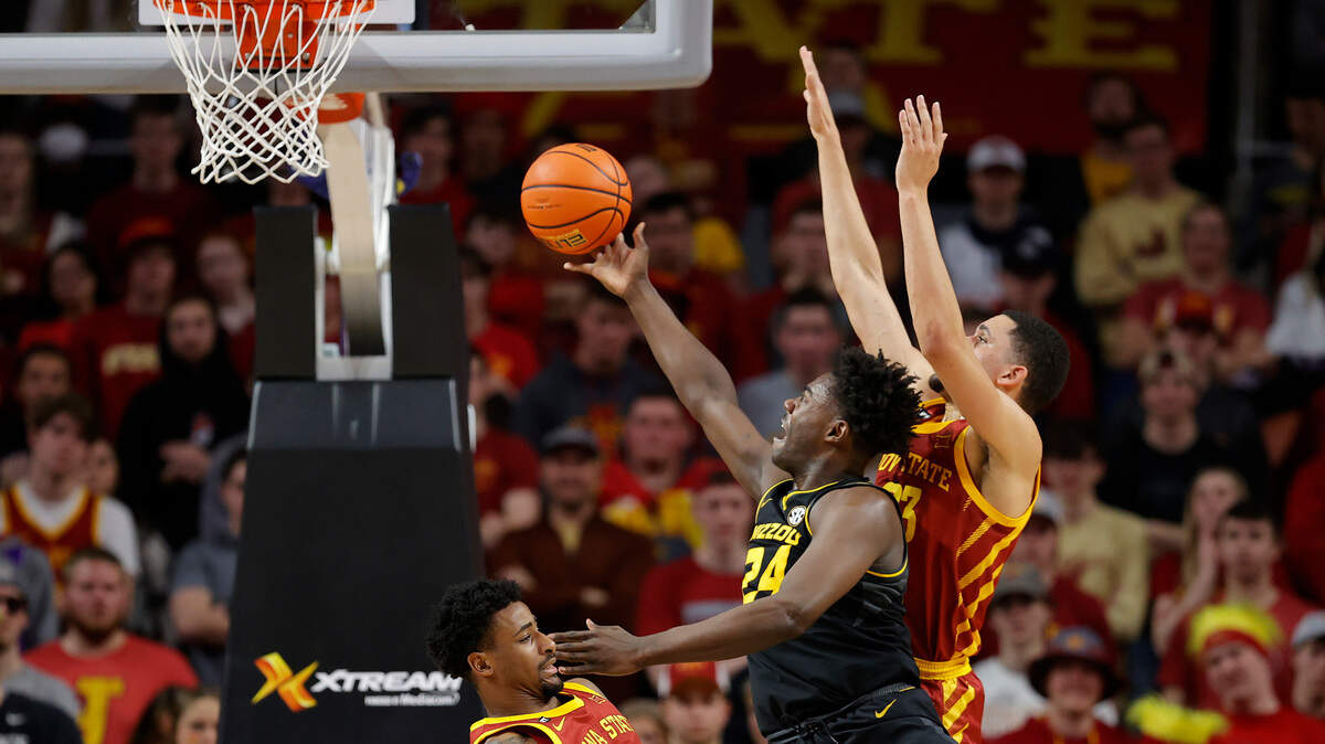 Missouri forward Kobe Brown (24) finds a shot past Iowa State guards Izaiah Brockington (1) and Tristan Enaruna (23) during the first half of an NCAA college basketball game, Saturday, Jan. 29, 2022, in Ames. (AP Photo/Matthew Putney)