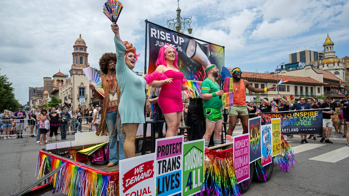 Members of the Heartland Men’s Chorus ride the float past the Country Club Plaza during the KC Pride Parade on Saturday, June 8, 2024, in Kansas City.