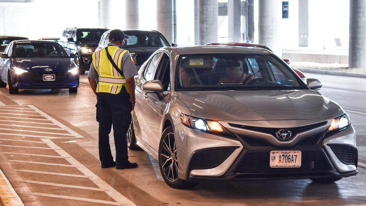 Traffic control officer Clyde Kemp Jr. speaks to an idling driver Wednesday at the arrivals curb of Kansas City International Airport.