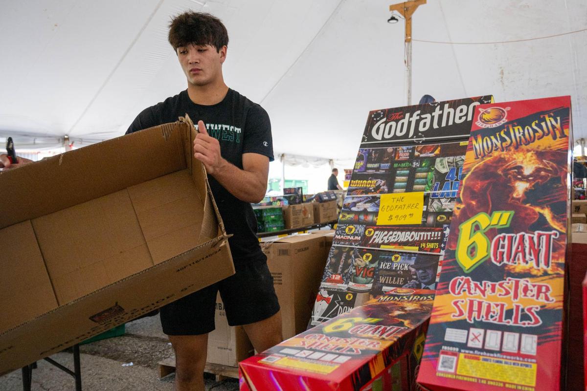 Tommy Hutsler unpacks boxes of fireworks at Red X Fireworks in Riverside on Thursday, July 3, 2025. The day before Independence Day is the busiest day of the year for fireworks stands like this.