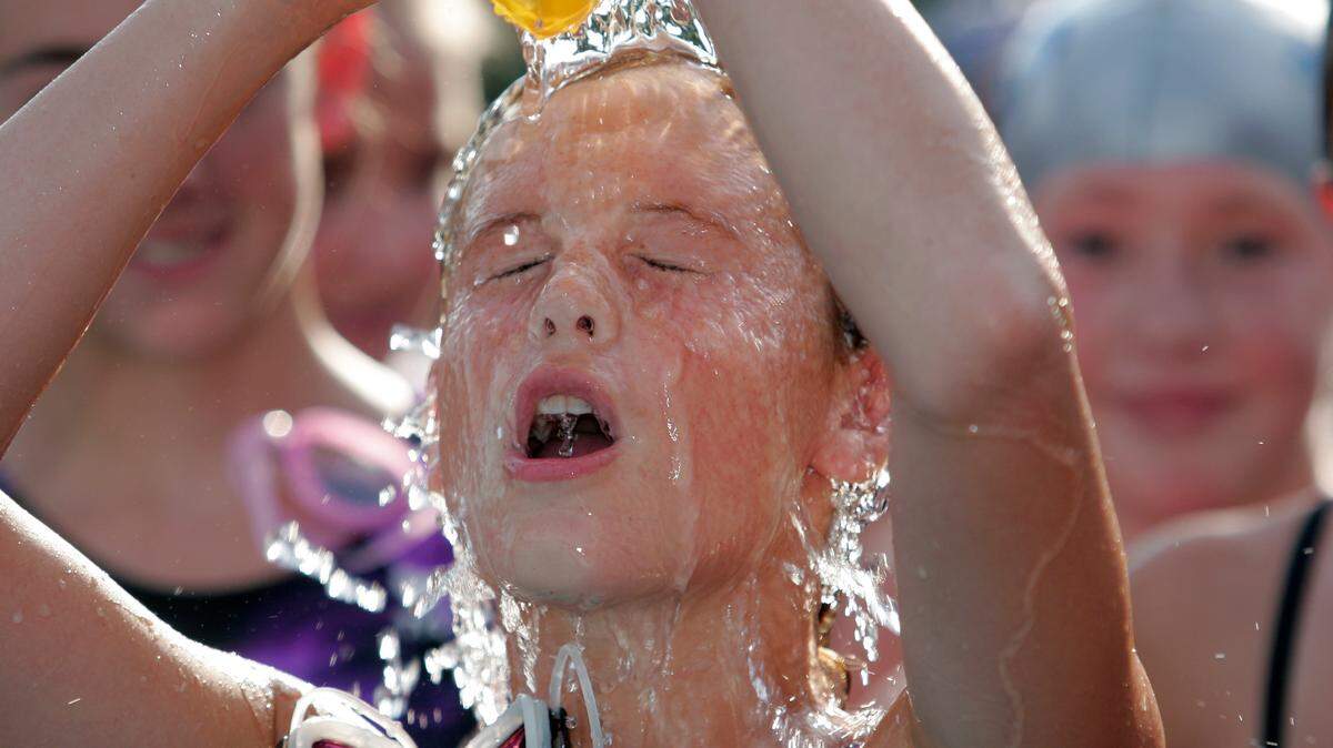In this file photo, a bathing cap full of water provided relief from the scorching heat for a swimmer during a swim meet.