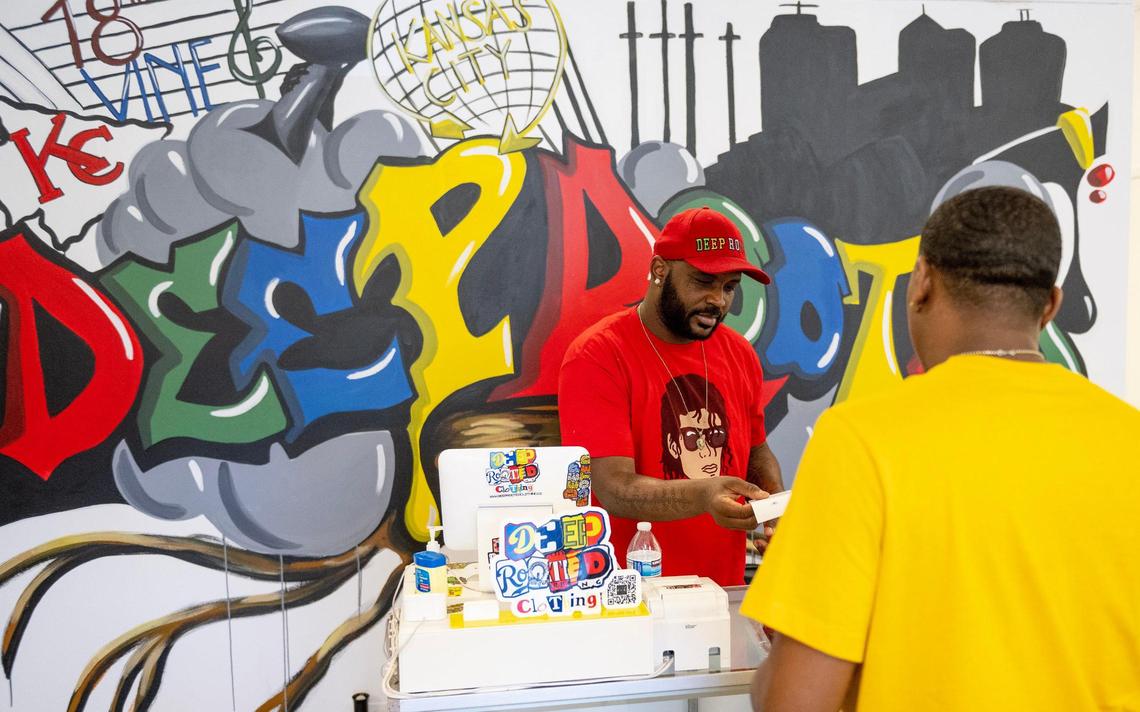 Donnell Jamison helps a customer at his new Deeply Rooted store, which opened last month.