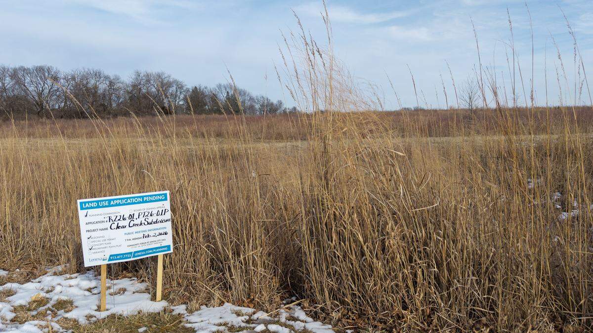 A sign alerting residents to a proposed 50-home Habitat for Humanity development is seen on Monday, Feb. 2, 2026, at the Clear Creek Trail area in Lenexa. Located off Clare Road near 86th Terrace, the site features a walking trail that leads to a small lake and a surrounding wetlands area.