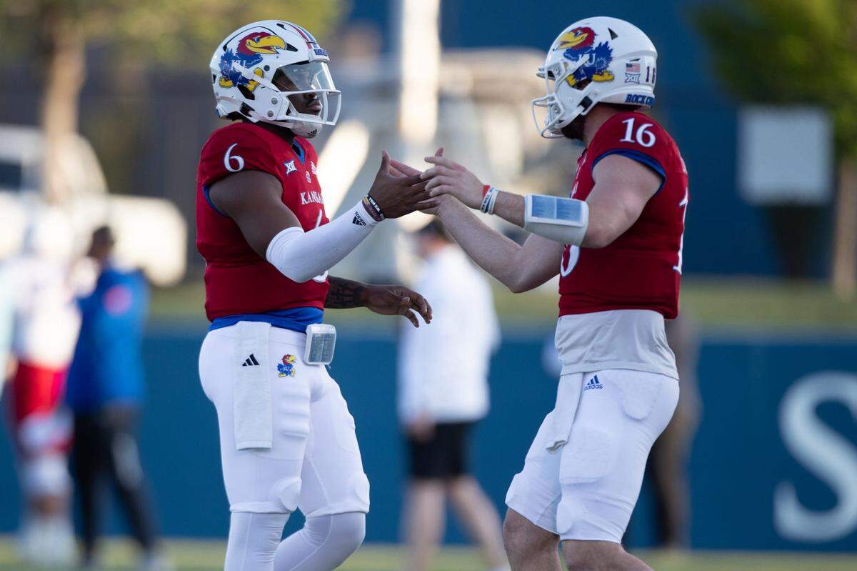 Kansas quarterback Jalon Daniels (6) slaps hands with fellow QB Ben Easters (16) during Friday’s Spring Showcase at Rock Chalk Park on April 12, 2024.