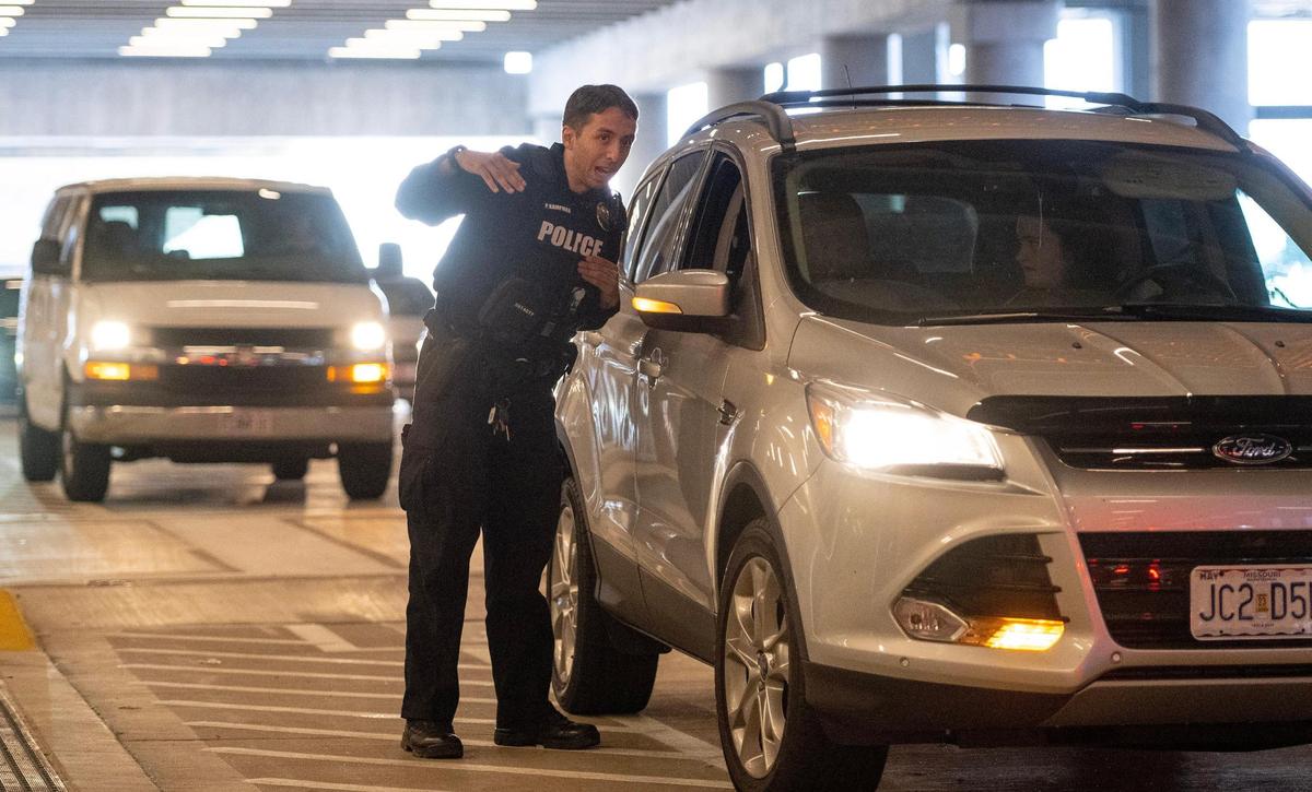 An airport police officer informs a motorist there is no waiting for arriving passengers in the pickup area at Kansas City International Airport on Sunday, March 5, 2023, in Kansas City.