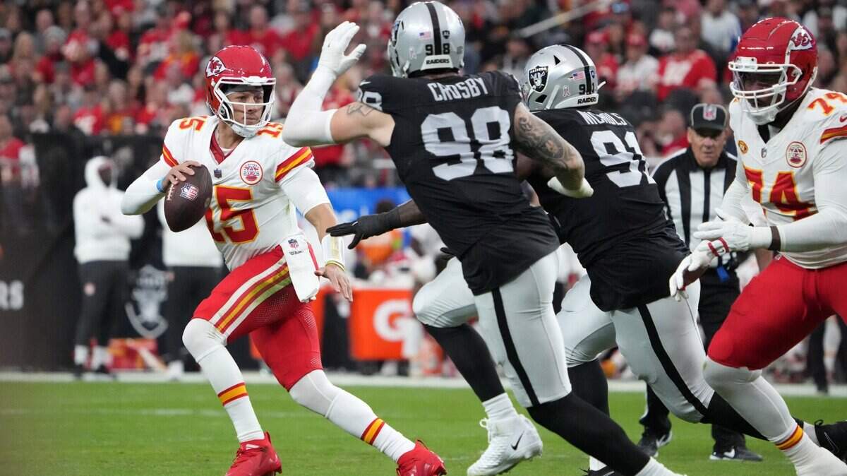Photo of Chiefs quarterback Patrick Mahomes running from Raider defenders.