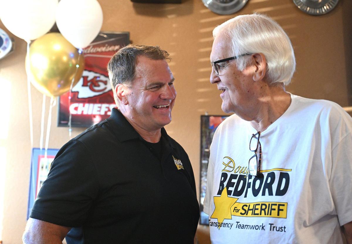 Doug Bedford, Republican candidate for Johnson County Sheriff, left talked with Ed Eilert, retired chairman of the Johnson County Board of County Commissioners, who was on hand to support Bedford at a watch party at J.T.’s Grill on Tuesday, Aug. 6, 2024, in De Soto, Kansas.