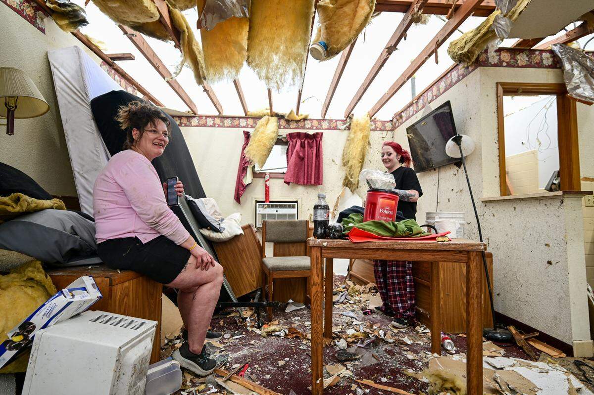 Rachelle Wolf, left, felt fortunate to be alive while she sat in the apartment where she lives in Nevada, Missouri, after it was heavily damaged by a tornado Wednesday, April, 2, 2025. Wolf survived by taking shelter in a bathtub. Wolf’s friend, Cheyenne Coale, right, was at the room to help after the storm.