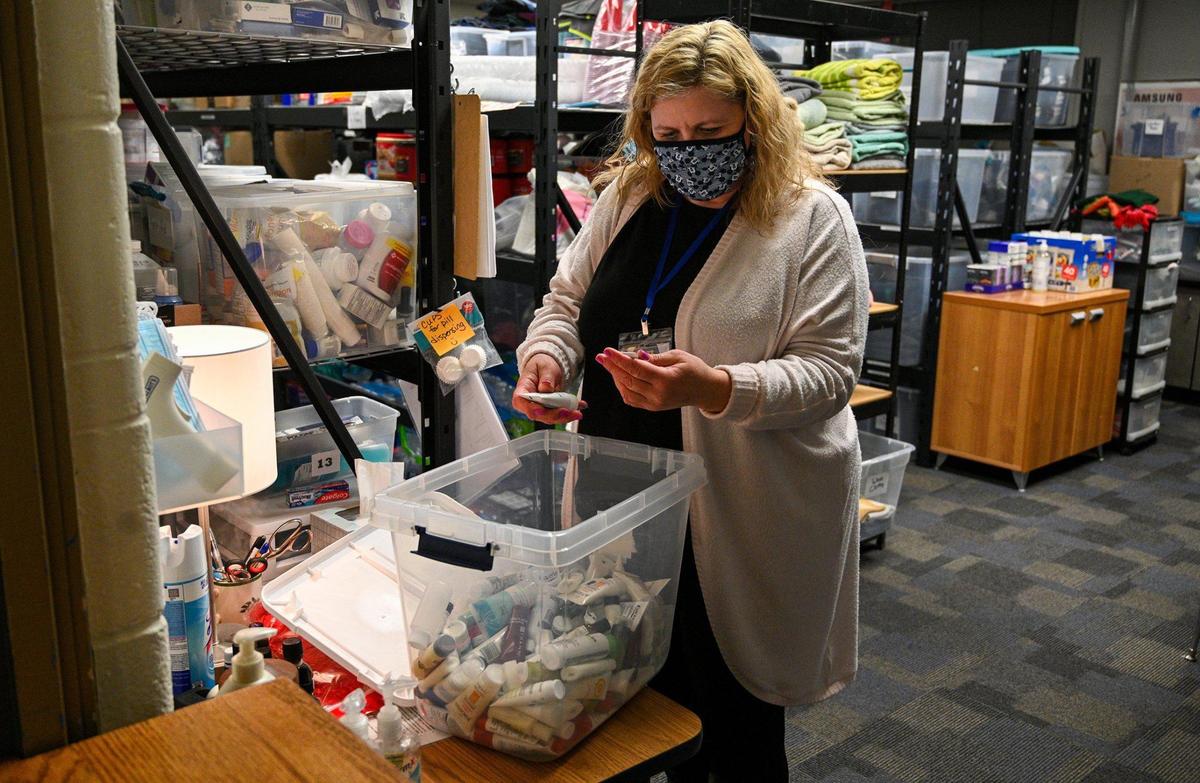 In the supply room, Patti Payne looks for personal items for a guest. Volunteers conducted an annual point-in-time survey of people experiencing homelessness at Project 10-20 in Lenexa, Tuesday, Jan. 25, 2022. Temperatures dropped into the low teens that night.