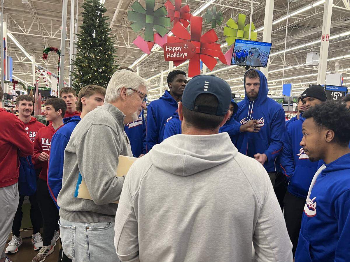 Former KU player Roger Morningstar instructs current basketball players ahead of their annual holiday shopping tradition.