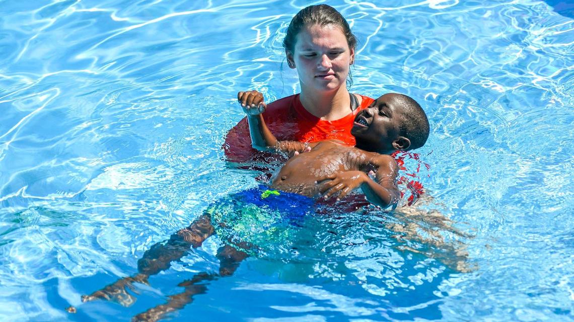 Swim instuctor Mackenzie Jones worked on getting Devronski Jones, 5, acclimated to the water during a swim lesson on Wednesday, July 13, 2022, at the Parkwood Pool in Kansas City, Kansas. With a sponsorship from GEHA, the pool has teamed up with the YMCA of Greater Kansas City, to provide swim lessons to 200 local children at the recently re-opened pool. During an employee donation drive GEHA employees donated googles, sunscreen and swim suits. The health benefits company also provided towels and swim caps for the children in the lessons.