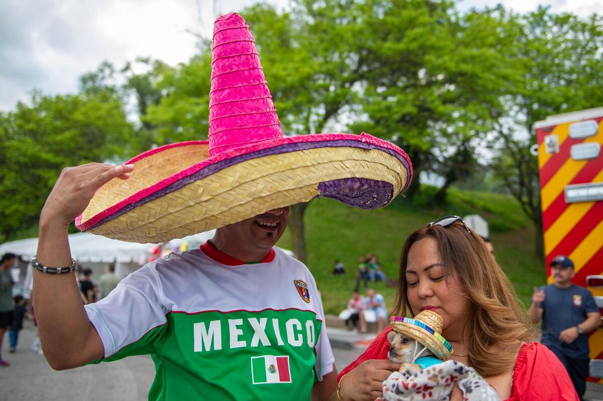 Eric Perea, left, and Madeth Perea adjust their puppy Simba’s sombrero during the Cinco de Mayo celebration at Guadalupe Centers on Friday, May 5, 2023, in Kansas City.