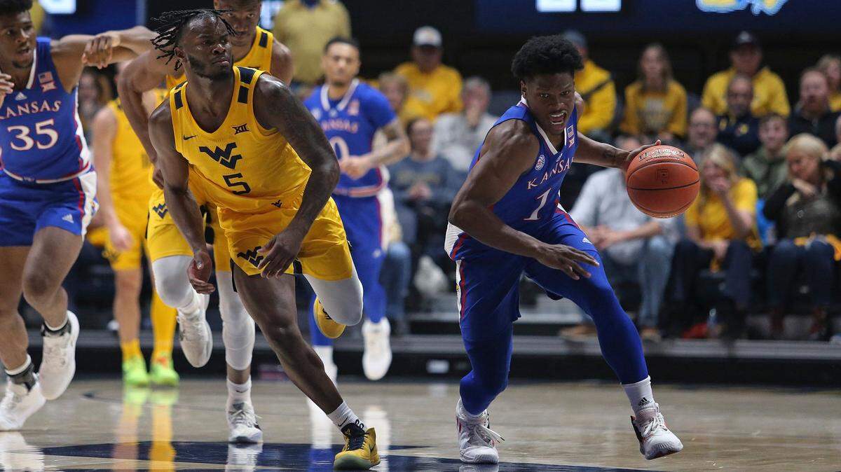 Kansas guard Joseph Yesufu, right, dribbles around West Virginia guard Joe Toussaint during Saturday’s game in Morgantown, W.Va.