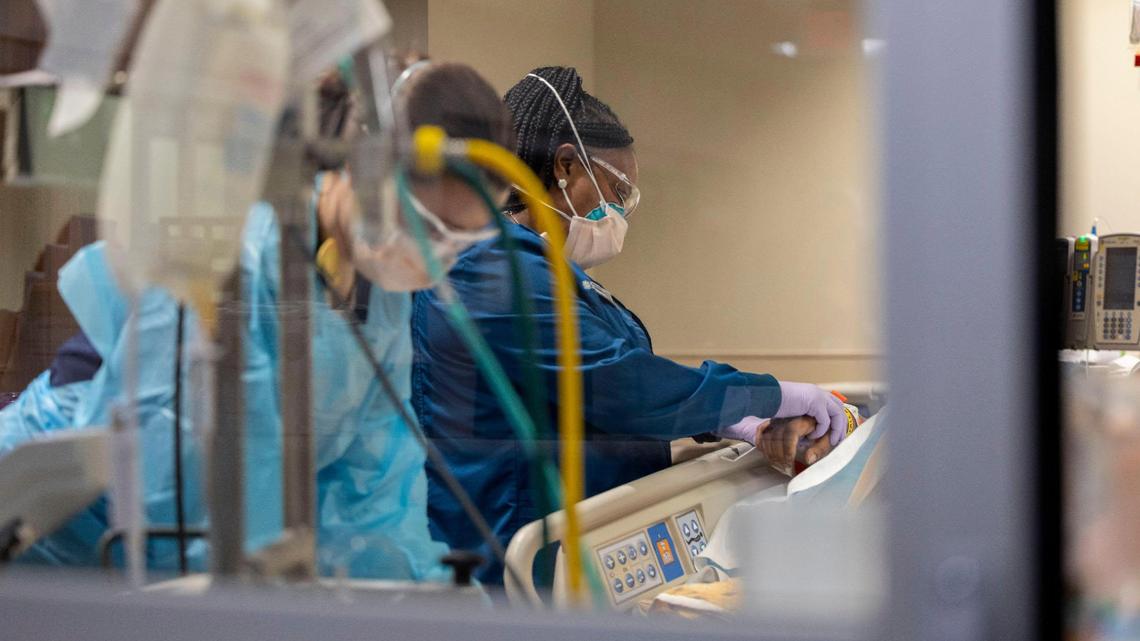 Medical workers at Saint Luke’s Hospital of Kansas City care for a severely infected COVID-19 patient in an isolated room at the Cardiovascular Intensive Care Unit on Tuesday, Jan. 18, 2022.