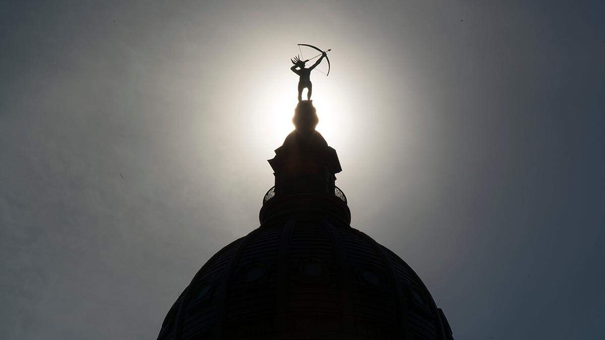 Ad Astra, the bronze statue of a Kansa warrior, is silhouetted atop the dome of the Kansas Statehouse.20160609 Capitol Outside Dome En