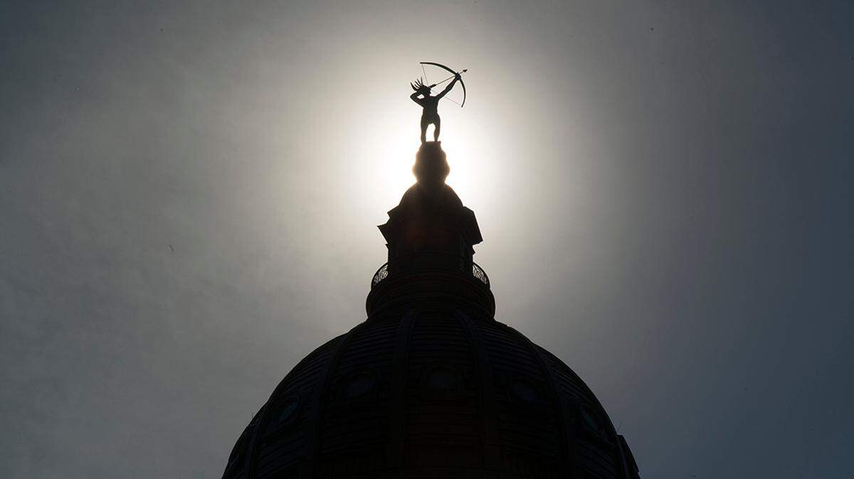 Ad Astra, the bronze statue of a Kansa warrior, is silhouetted atop the dome of the Kansas Statehouse.

20160609 Capitol Outside Dome En