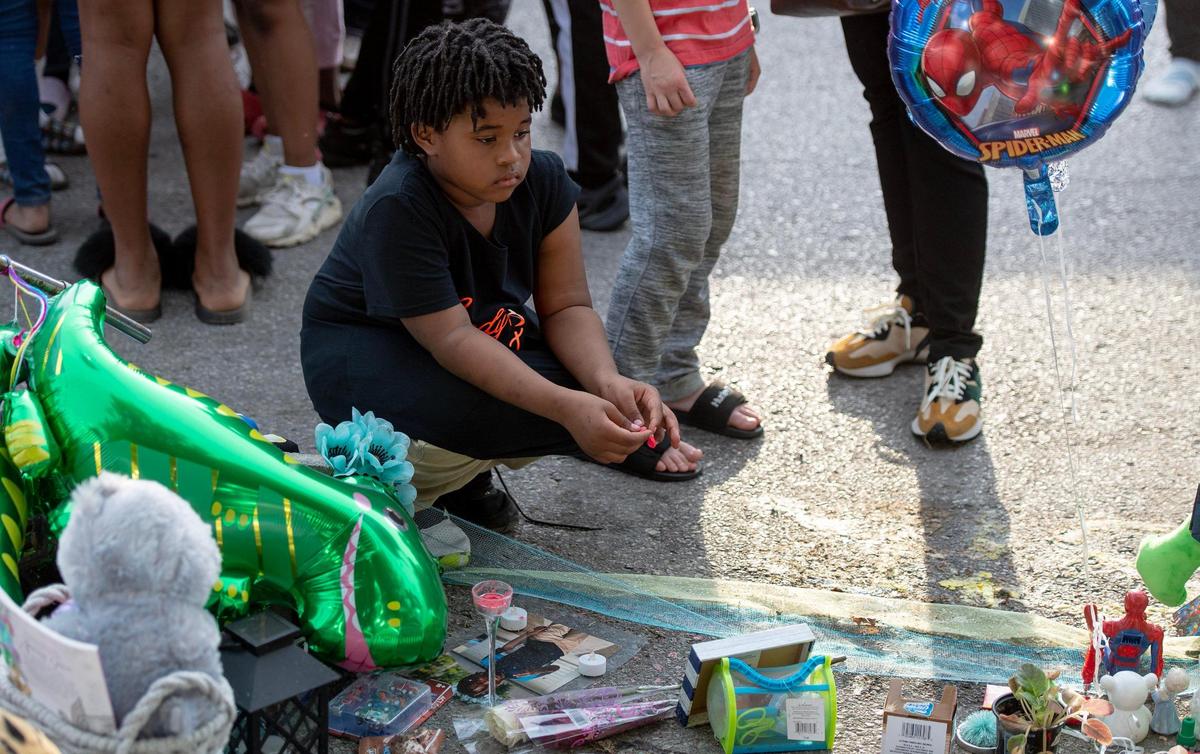 A boy looks at a memorial during a vigil for 6-year-old Sir’Antonio Brown on Wednesday, May 10, 2023, in Kansas City, Kan. Brown was killed May 3 while playing outside his home.