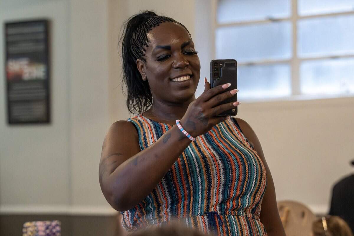 Korea Kella records video on a mobile device while attending a Trans Day of Remembrance event at Spirit of Hope MCC on Tuesday, March 31, 2026, in Kansas City.