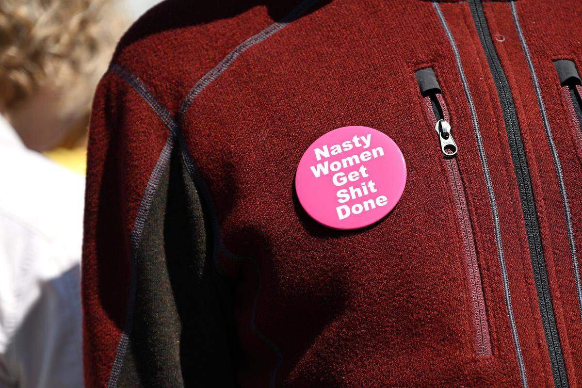 A protester wears a large button during a No Kings protest at Mill Creek Park near the Country Club Plaza on Saturday, March 28, 2026, in Kansas City.