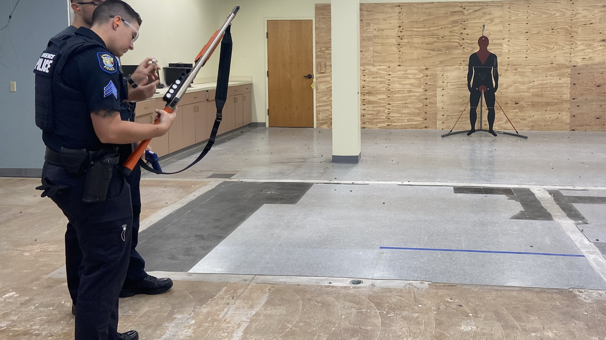 Sgt. Meagan Shipley prepares to fire a beanbag gun with Officer Chase Fraser in a training demonstration. Lawrence police transitioned from shotguns to the less-lethal beanbag gun this week.