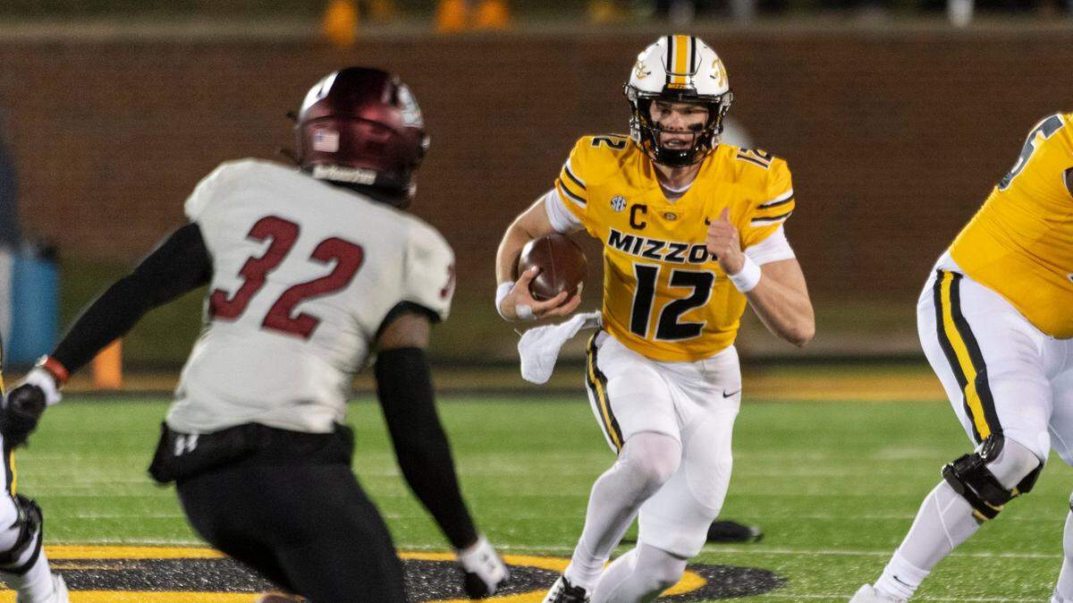 Missouri Tigers quarterback Brady Cook scrambles as New Mexico State defensive back Bryce Jackson closes in Saturday night in Columbia, Mo.