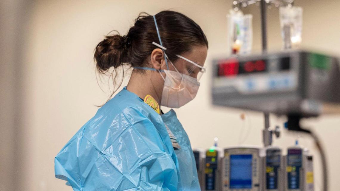Allyse Dowell, a registered nurse at Saint Luke’s Hospital of Kansas City, cares for a severely infected COVID-19 patient at the Cardiovascular Intensive Care Unit on Tuesday, Jan. 18, 2022. Dowell withdraws blood from the patient to measure their oxygen levels.