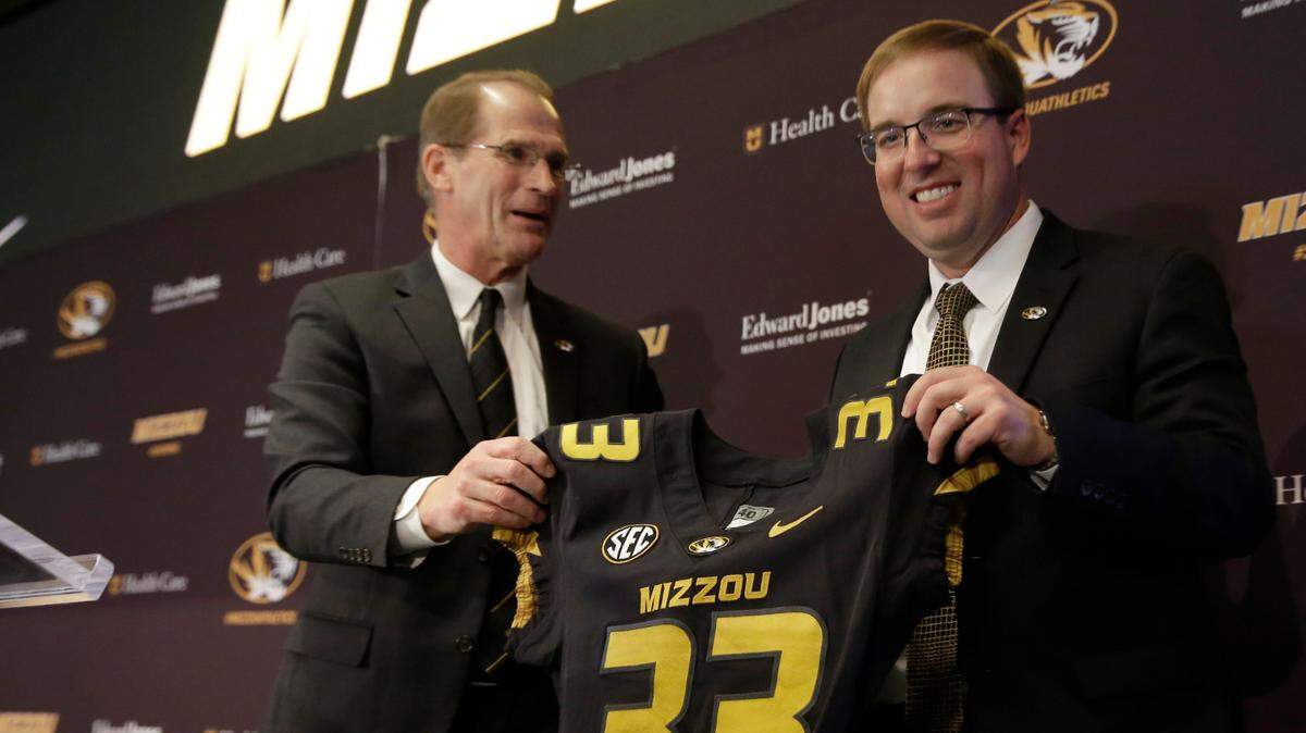 Missouri athletics director Jim Sterk, left, holds up a jersey with Eliah Drinkwitz after introducing Drinkwitz as the new head football coach at the University of Missouri Tuesday, Dec. 10, 2019, in Columbia, Mo. Drinkwitz becomes the 33rd head football coach at Missouri after coaching the 2019 season at Appalachian State. (AP Photo/Jeff Roberson)