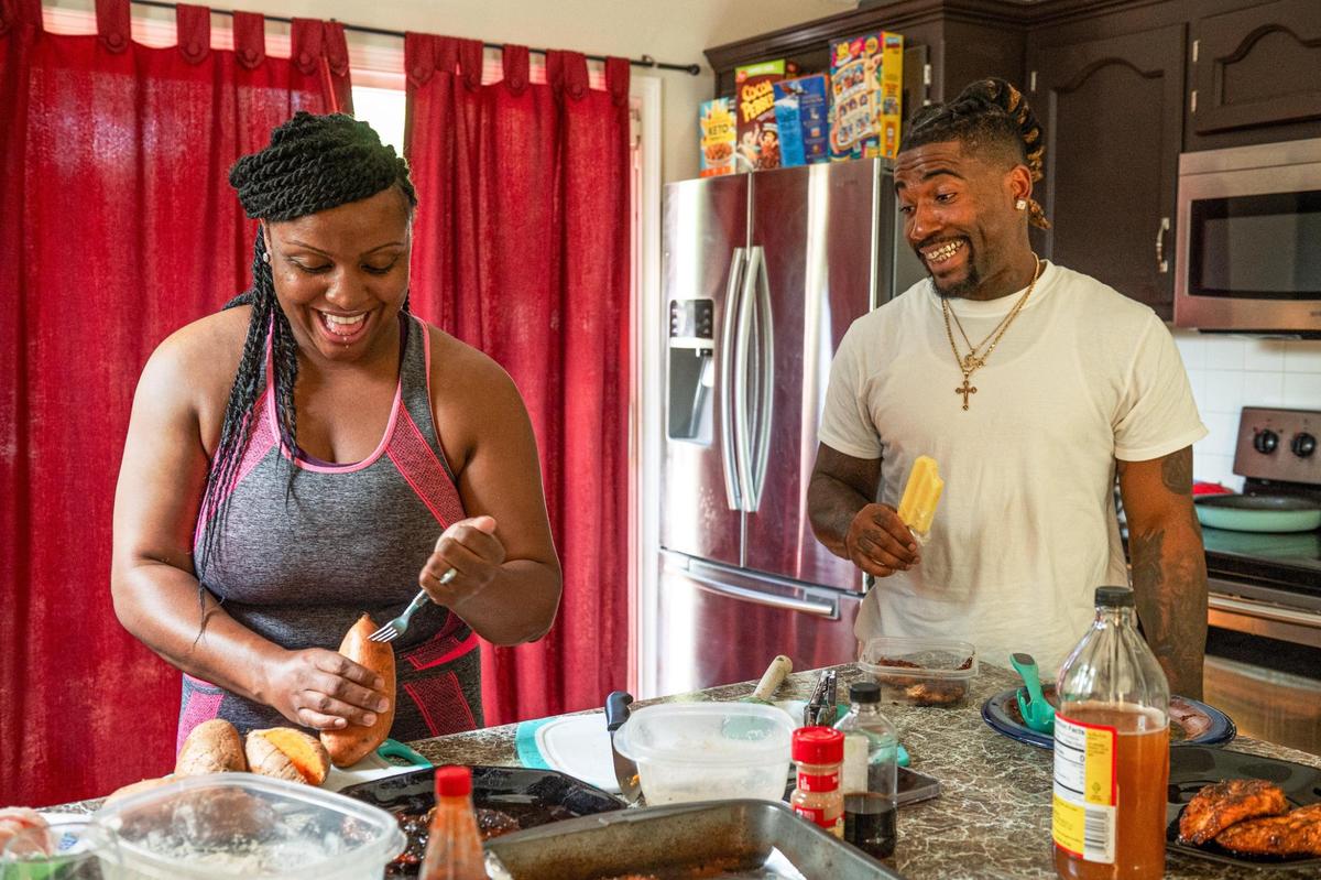 Mika Roddy and John Roddy share a laugh while she prepares dinner at their home in Blue Springs.