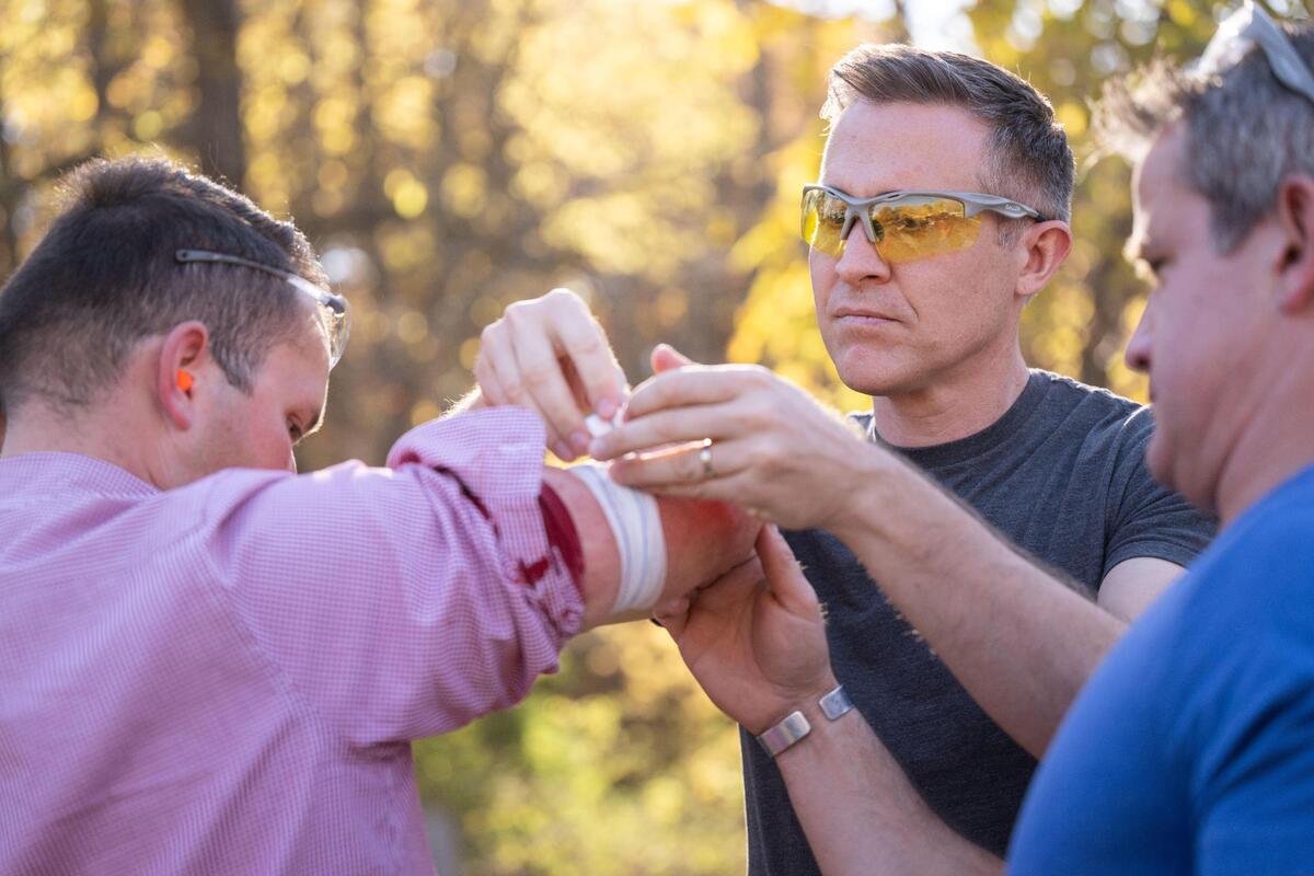 Missouri Democratic candidate for U.S. Senate Lucas Kunce applies first aid to KSHB 41 reporter Ryan Gamboa after Gamboa was struck by ricochet from a bullet fragment during a sport shooting campaign event Tuesday, Oct. 22, 2024 n Holt, Missouri.