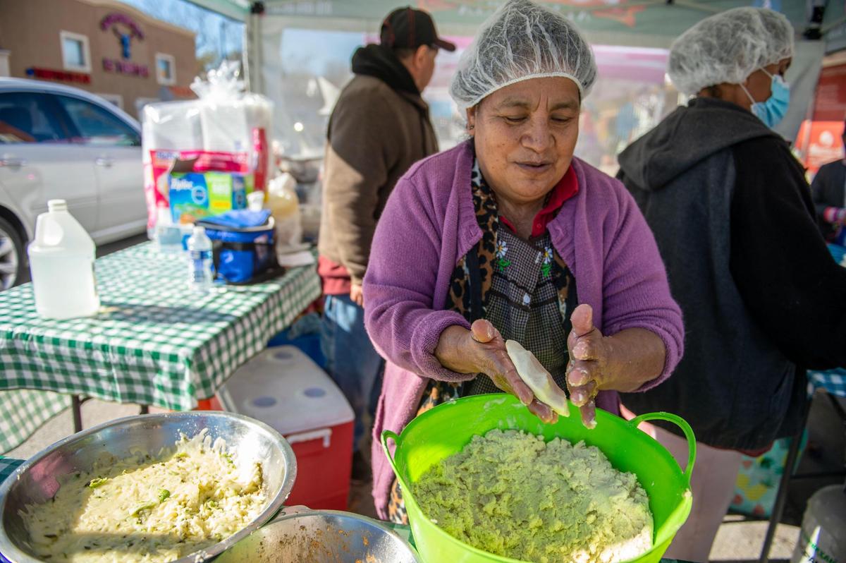 Berta Rosales makes a hand-pressed pupusa at the Pupusas Ala Parilla booth during the Dia de Los Muertos celebration on Nov. 5, 2022, in Kansas City, Kansas.