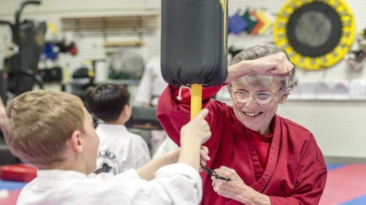 
Helen Dugan, owner Champs Achievers martial arts school in Lenexa, shows a defensive move to 7-year-old Brayden Bond.
