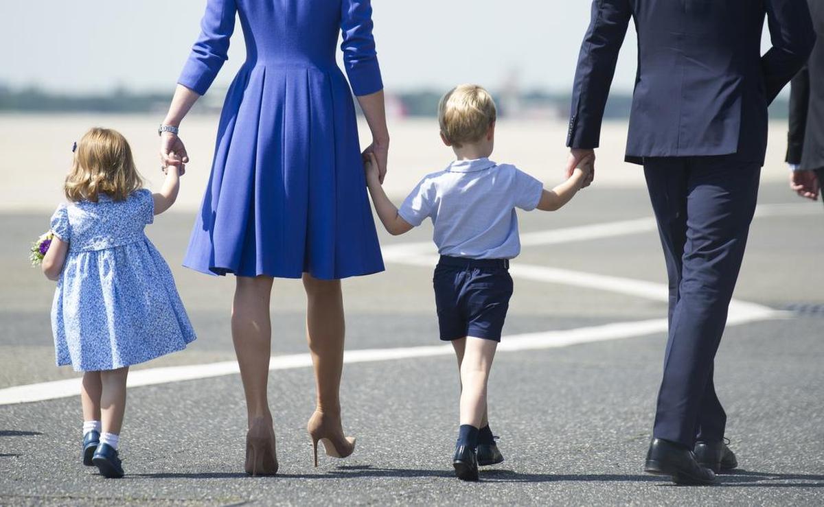 This July 19, 2017, file photo shows Britain’s Prince William and wife Kate, the Duchess of Cambridge, walking with their children Prince George and Princess Charlotte at the airport in Berlin during a three-day-visit in Germany.