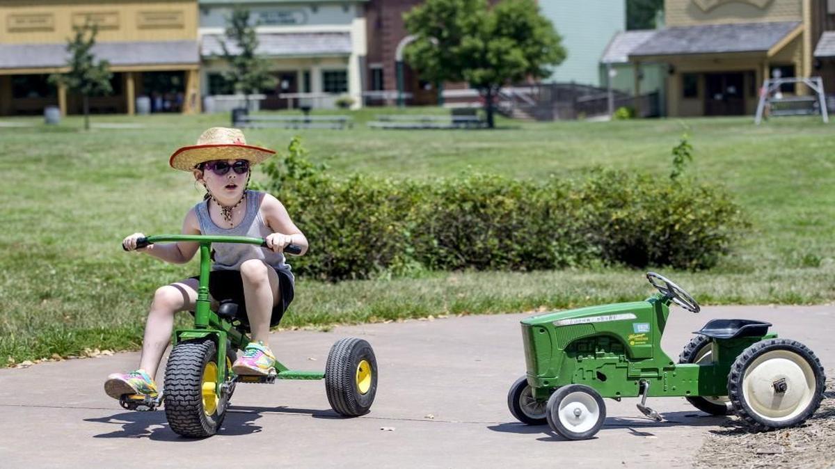 Lillian Bartley, 5, and of Overland Park, rides a pedal tractor on at Deanna Rose Children’s Farmstead in Overland Park. WalletHub named Overland Park the best city for families in the United States; the Farmstead and other family attractions are among the reasons why.