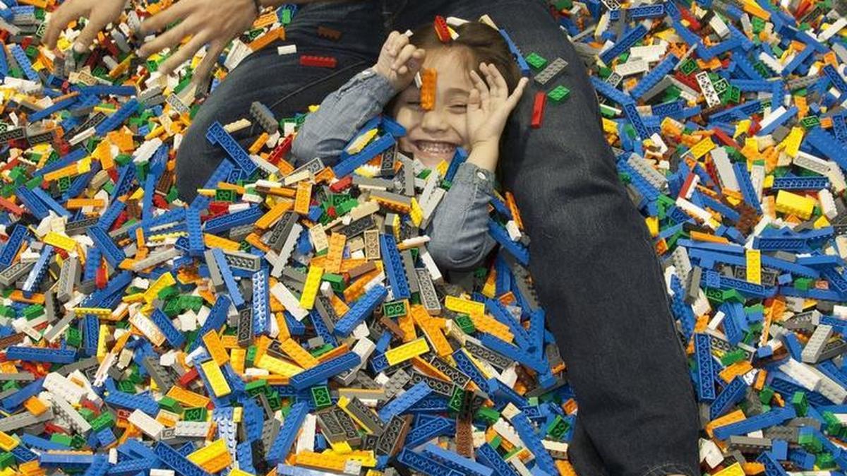 Edgar Castaneda of Independence, buried his daughter Camila Castaneda, 4, in Lego bricks on Sunday, May 15, 2016 at the Lego KidsFest at the Kansas City Convention Center, Bartle Hall.